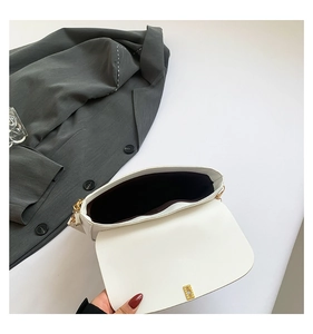 Interior view of white leather chain bag showing dark lining and gold lock detail