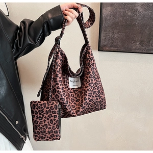 Detail of leopard print large shoulder bag with matching mini pouch on soft fabric