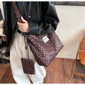 Detail shot of a leopard print tote bag with wide strap and matching mini pouch