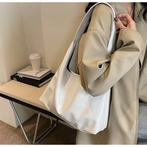 Détail d'un sac hobo blanc à texture plissée brillante et large bandoulière d'épaule