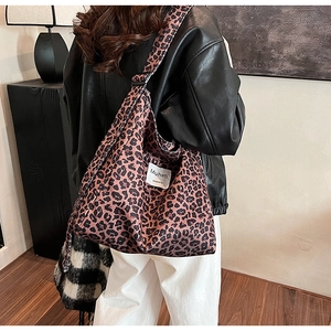 Close-up of leopard print canvas tote bag showing textile texture and brand label