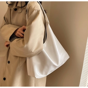Sac hobo blanc en similicuir avec texture fine et grande capacité porté à l'épaule