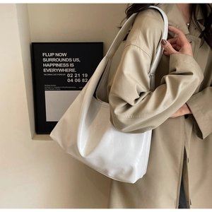Détail du sac hobo en similicuir blanc avec large bandoulière et texture délicate
