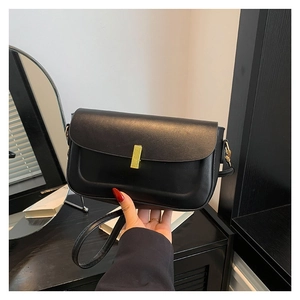 Minimalist black leather crossbody bag with elegant gold metal lock and leather strap