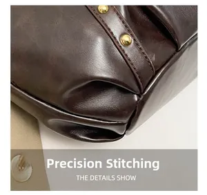 Vue macro du sac en cuir marron foncé avec coutures de précision et clous en métal doré