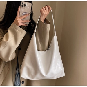 Détail d'un sac cabas blanc brillant en similicuir avec large bandoulière épaule