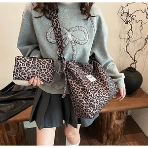 Detail of leopard print canvas bag set with adjustable strap and matching small pouch