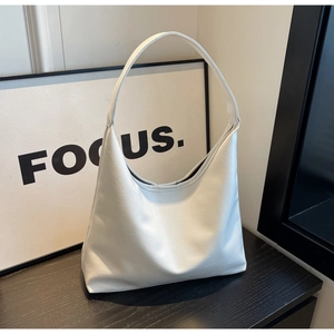 Sac fourre-tout minimaliste en similicuir blanc avec une large bandoulière souple
