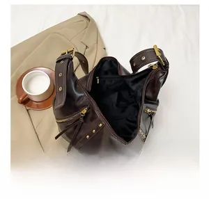 Vue détaillée de l'intérieur du sac marron montrant le compartiment et la poche zippée