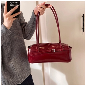 Close-up of deep burgundy rectangular baguette bag with glossy finish and silver buckle