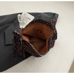Detailed view of leopard print canvas tote with internal pocket on grey suit fabric