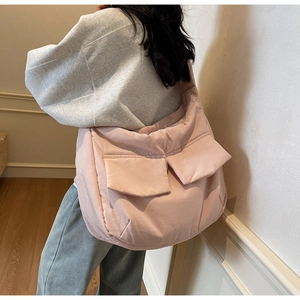 Detailed view of pink quilted crossbody bag showing double front flap pockets and soft texture