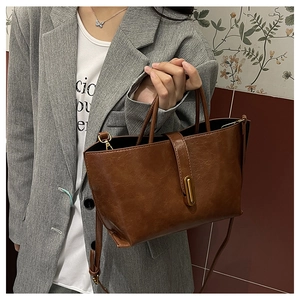 Détail du sac cabas en similicuir marron avec boucle dorée et bandoulière réglable