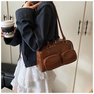 Detail showing deep brown faux leather texture and dual front zip pockets on underarm bag