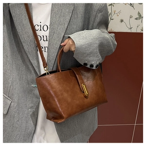 Gros plan du sac cabas vintage en cuir marron avec boucle dorée et bandoulière fine