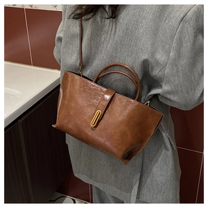 Détail d'un sac cabas marron vintage avec fermoir doré élégant et doubles anses de main