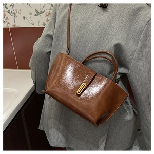 Détail du sac vintage en cuir huilé marron avec boucle dorée et fini texturé