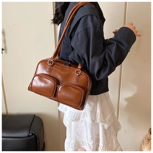 Detail of vintage brown PU leather shoulder bag with functional dual front zip pockets