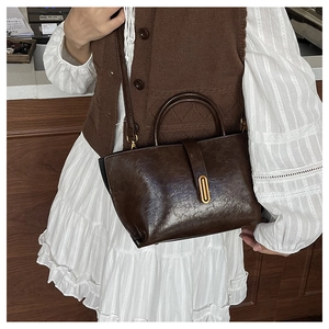 Détail d'un sac cabas marron vintage en cuir huilé avec un fermoir en métal doré
