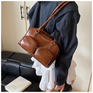 Detail view of retro brown leather shoulder bag with two functional front zipper pockets