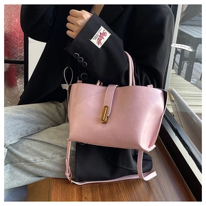 Détail du sac cabas en cuir rose brillant avec fermoir doré et bandoulière réglable