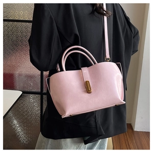 Détail du sac cabas en simili cuir rose avec fermoir doré et pieds de protection