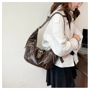 Vue détaillée du sac hobo en cuir vintage marron foncé avec des rivets dorés