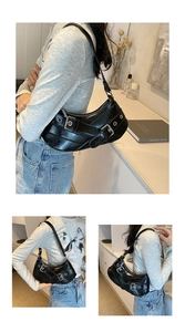 Detail view of black punk style crescent underarm bag with decorative metal buckles and eyelets