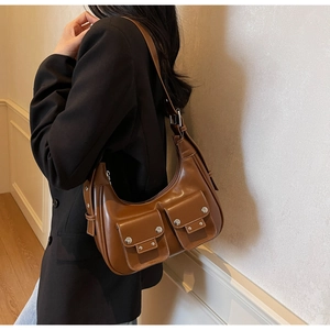 Brown hobo bag with front pockets and silver studs shown on a model for scale