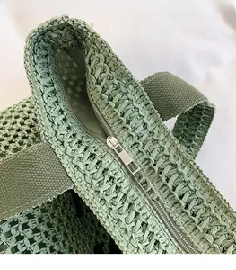 Detail of woven tote bag with silver metal zipper and durable canvas handles