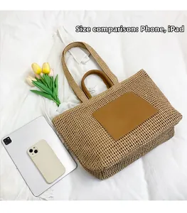 Large khaki straw tote bag detail showing size comparison with phone and iPad