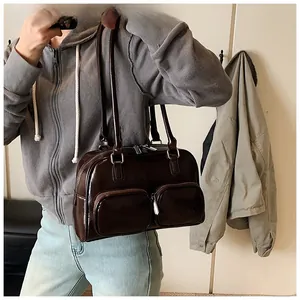 Detail view of deep brown glossy PU leather underarm bag with double front zip pockets