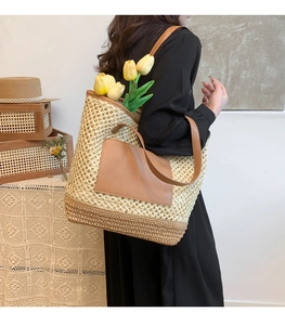 Detail view of woven straw tote bag with brown leather patch and stylish tulip accent