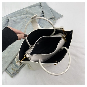 Vue détaillée du sac cabas en cuir blanc avec pochette intérieure et boucles dorées