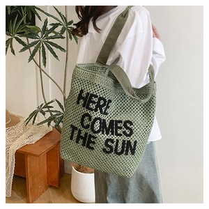 Detail of green knit tote bag with Here Comes The Sun text and wide shoulder straps