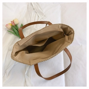 Top view of woven tote interior with beige fabric lining and spacious zipper pockets