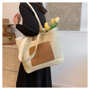 Detail of summer straw tote bag showing brown faux leather pocket and woven texture