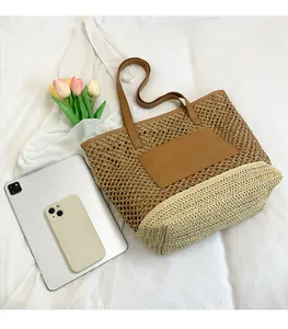 Detail of hollow woven straw tote bag with brown leather pocket and large capacity
