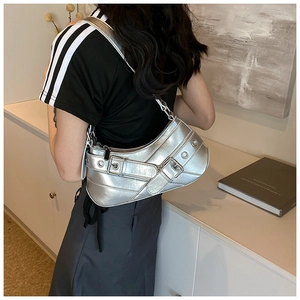 Detail of silver metallic hobo bag with dual buckle straps and eyelets on shoulder strap