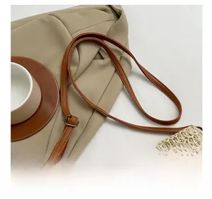 Detail of adjustable brown leather strap and beige straw bag weaving for summer