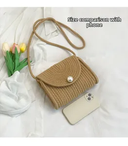 Detail of straw woven bag with pearl clasp and smartphone for size comparison