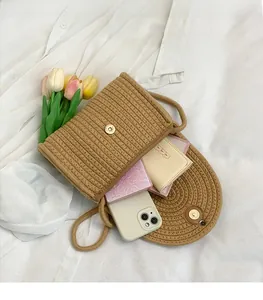 Detail of khaki straw woven crossbody bag with metal magnetic clasp and interior space