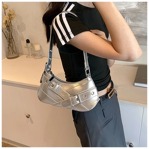 Detail of silver metallic hobo bag with buckled straps and metal eyelet accents