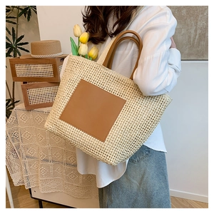 Close-up of summer woven straw tote bag with brown leather patch and fresh tulip accents