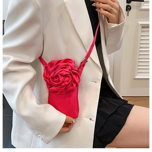 Détail d'une grande fleur 3D en tissu rouge rose sur un sac à bandoulière pour femmes