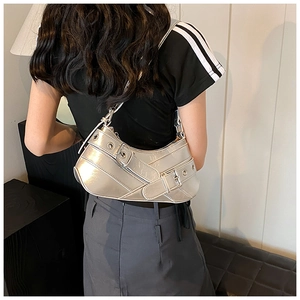 Detail view of silver metallic Y2K shoulder bag with grommet straps and buckle details