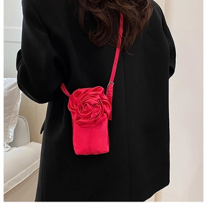 Détail du sac à bandoulière en satin rouge avec rose 3D et boucle en métal argenté