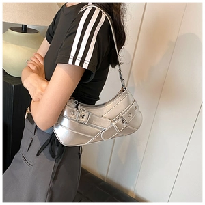 Detail view of silver metallic Y2K shoulder bag with grommets and adjustable buckle strap