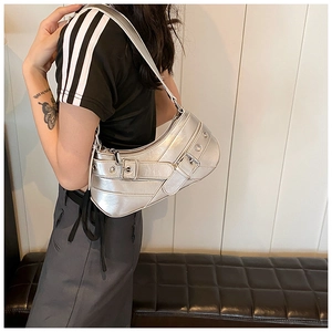 Silver Y2K metallic underarm bag with buckles shown on a model for style and scale
