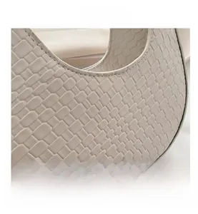 Detailansicht der weißen gewebten Lederstruktur einer Crescent Schultertasche